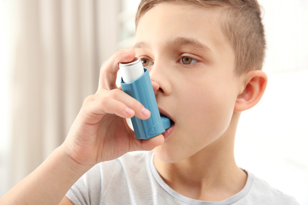 a boy using asthma inhaler